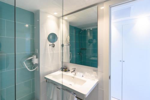 łazienka z umywalką i lustrem w obiekcie Plaza Santa Ponsa Boutique - Adults Only. w miejscowości Santa Ponsa
