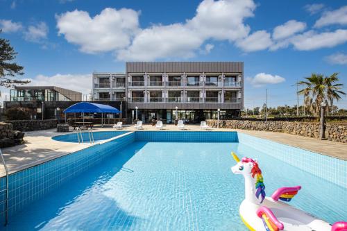 a pool with a unicorn in front of a building at Dammora Resort in Seogwipo