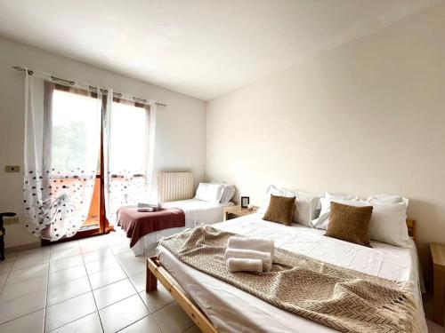 Cassero的住宿－[Idromassaggio] Relax, wi-fi, bbq & parcheggio，一间卧室设有两张床和大窗户