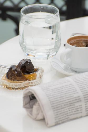 a table with a book and a cup of coffee at Angelica Hotel in Limenas