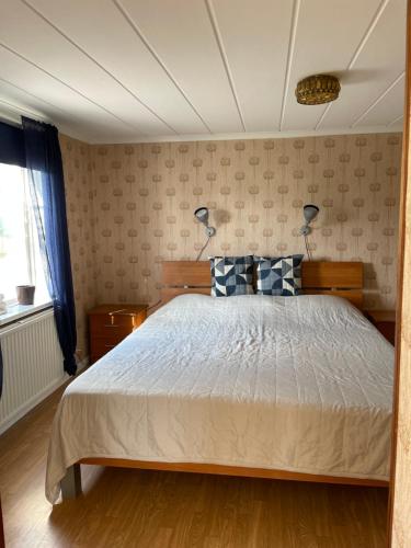 a bedroom with a bed with two blue and white pillows at Patterdale farm holiday apartments in Gamleby