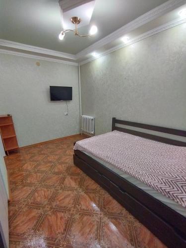a bedroom with a bed and a flat screen tv at Жилье в Кропивницком in Kropyvnytskyi