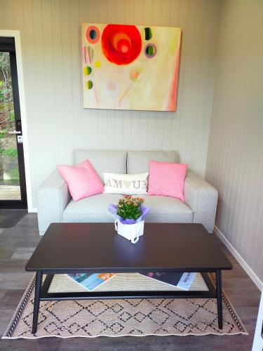 a living room with a couch and a coffee table at Secluded, private rural retreat mins from Warkworth -"Avondale" Minihouse in Warkworth