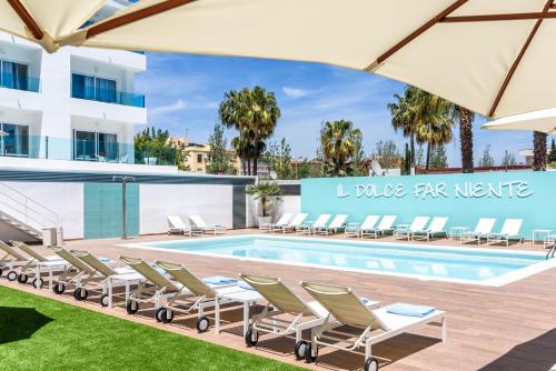 a pool with chaise lounge chairs and a hotel at Plaza Santa Ponsa Boutique - Adults Only. in Santa Ponsa