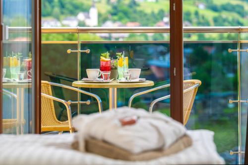 a table with two cups of coffee on it next to a window at Relax Resort Hotel Kreischberg in Sankt Georgen ob Murau