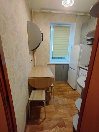 a small kitchen with a table and a refrigerator at Жилье в Кропивницком in Kropyvnytskyi