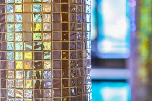 a brown tiled wall with different colored glass tiles at Relax Resort Hotel Kreischberg in Sankt Georgen ob Murau