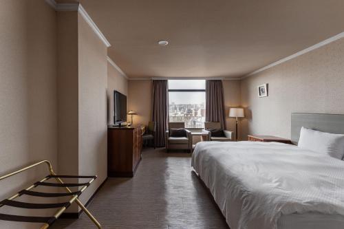 a hotel room with a bed and a chair and a window at Hotel j-Metropolis in Hsinchu City
