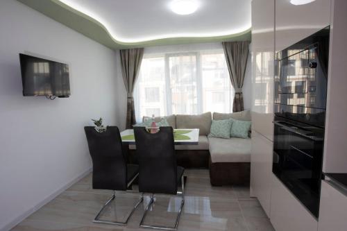 een woonkamer met een tafel en een bank bij Апартамент за гости Ивви-2 in Boergas