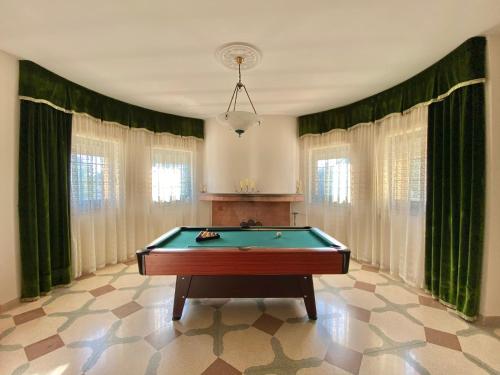 a pool table in a room with green draperies at La Campanella in Manduria