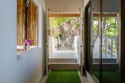 un couloir avec un tapis vert et une porte avec une fenêtre dans l'établissement Sunset House two bedroom home with sunset view, à Haad Yao