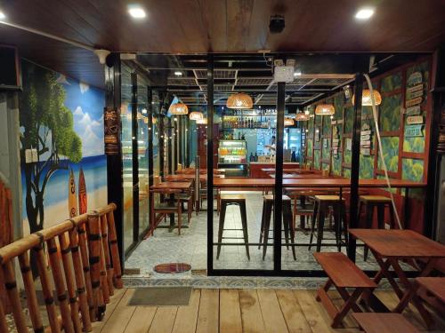 un restaurante con mesas de madera y sillas en una habitación en Happy Daze Resort Hotel, 