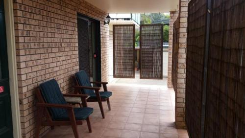 two chairs sitting on a patio with a brick wall at Dalmeny Shores in Dalmeny