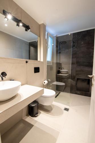 uma casa de banho com um lavatório, um WC e um chuveiro em Ennea suites-Storm suite em Flámbouras