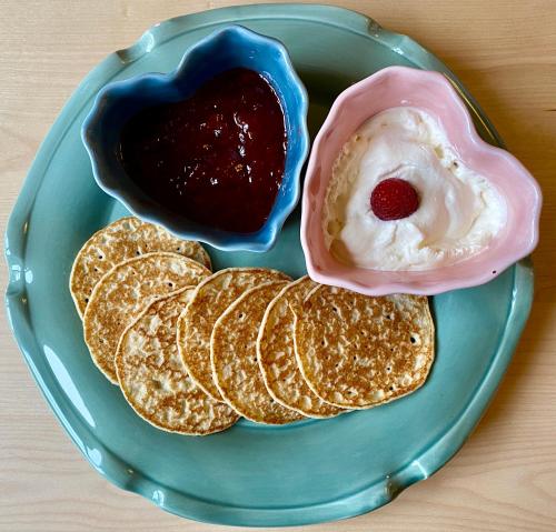 a blue plate with pancakes and a donut and sauce at Hotell St Clemens in Visby