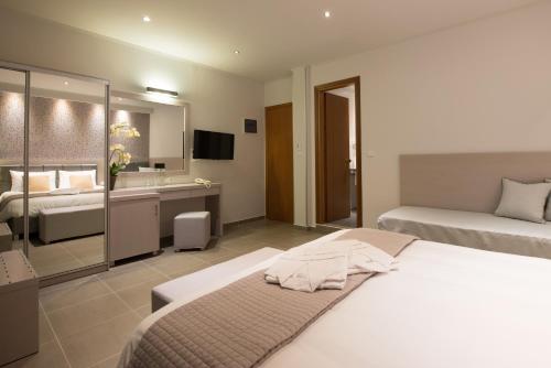 a hotel room with two beds and a bathroom at Angelica Hotel in Limenas