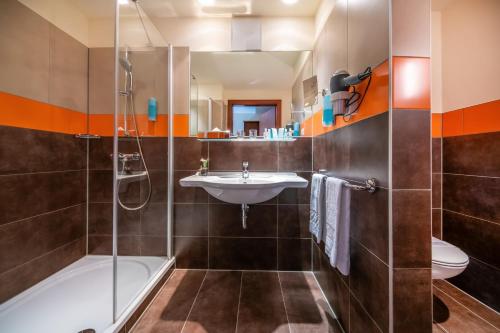 a bathroom with a sink and a shower and a toilet at Relax Resort Hotel Kreischberg in Sankt Georgen ob Murau