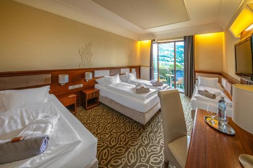 um quarto de hotel com duas camas e uma mesa em Relax Resort Hotel Kreischberg em Sankt Georgen ob Murau