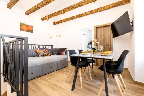 a living room with a table and a couch at Casa Maginja - Mediterranean Old Town Apartments in Veli Lošinj