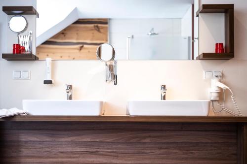 two sinks in a bathroom with two mirrors at Gastwirtschaft Hold in Mönichwald
