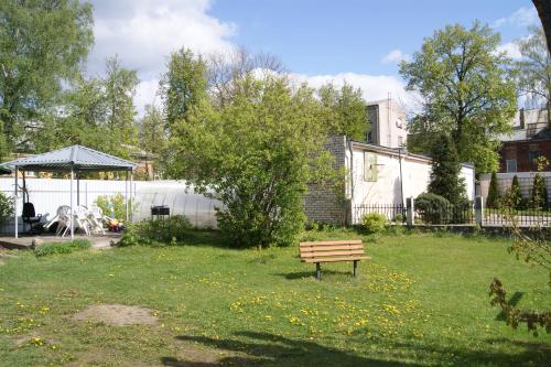 eine Parkbank in der Mitte eines Gartens in der Unterkunft Daugavpils city centre in Daugavpils