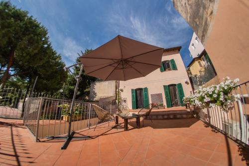 a patio with a table and an umbrella at Officine Bordighera in Bordighera