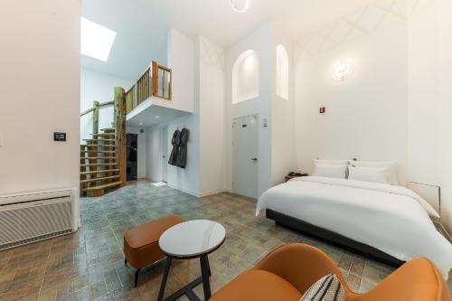 um quarto branco com uma cama e uma escada em Eumseong Hotel Luem em Eumseong