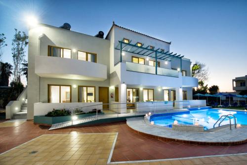 dom z basenem przed nim w obiekcie Mary Hotel & Mary Royal Suites w mieście Platanes