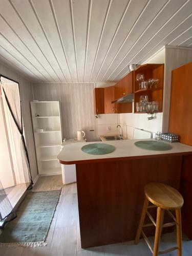 a kitchen with two sinks and a counter with a stool at Domki na wynajem w Kątach Rybackich in Kąty Rybackie