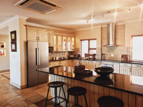 a kitchen with a refrigerator and some bar stools at Elements golf reserve in Bela-Bela