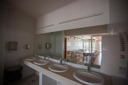 a bathroom with three sinks and a large mirror at HI Portimão - Pousada de Juventude in Portimão