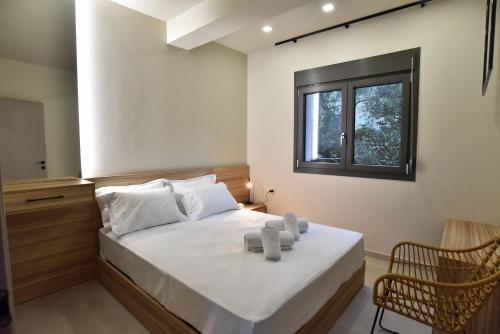 a bedroom with a large white bed with a window at Welcome Inn in Paleo Tsifliki