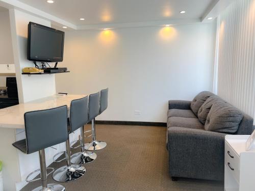a living room with a couch and a table and a tv at One-Bedroom Apartment in Honolulu