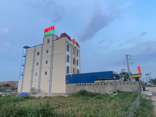 un edificio blanco con un letrero rojo y verde. en Khách Sạn Khánh Bình - Bình Dương, 