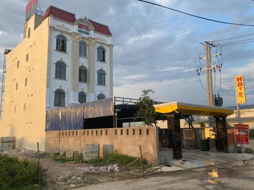 a large white building with a tower next to a bus stop at Khách Sạn Khánh Bình - Bình Dương in Tân Uyên