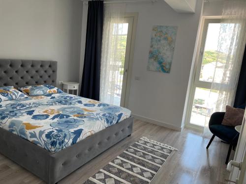ein Schlafzimmer mit einem Bett mit einer blau-weißen Bettdecke in der Unterkunft Apartament - Housing21 in Gura Humorului