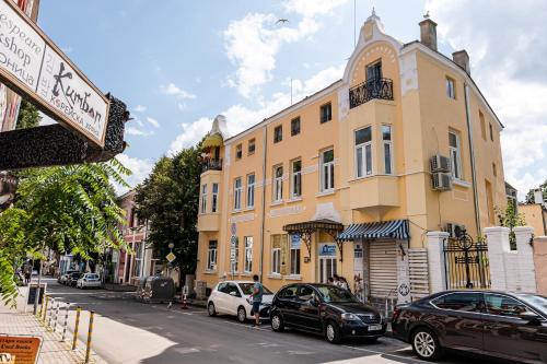 a yellow building with cars parked in front of it at Aristocratic 2bdrm Central Apartment in Varna City