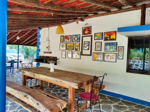 a dining room with a wooden table and pictures on the wall at Aqua Arina Holiday Farm House in Murud