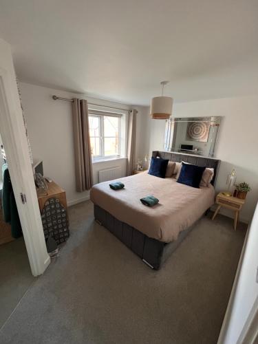 a bedroom with a large bed with blue pillows at Durham Homestay in Sacriston