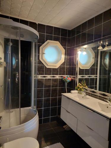 a bathroom with a tub and a toilet and a sink at Casa Elisei in Asău