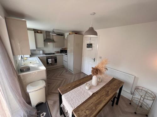 a kitchen with a wooden table and a kitchen with a sink at Durham Homestay in Sacriston