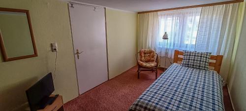 1 dormitorio con 1 cama, 1 silla y 1 ventana en Gemütliches Haus in Gartz/Oder, en Gartz an der Oder