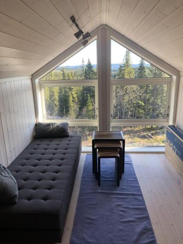 - un salon avec un canapé et une grande fenêtre dans l'établissement Sykkelhytte ved Slåtten i Synnfjellet, à Nord Torpa