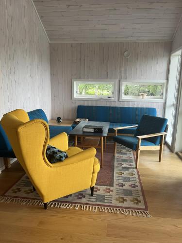 un salon avec une chaise jaune et une table dans l'établissement Sykkelhytte ved Slåtten i Synnfjellet, à Nord Torpa