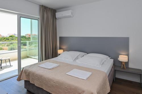 a bedroom with a bed with two towels on it at VILLA CALA, Hotel Rooms&Apartments in Novalja