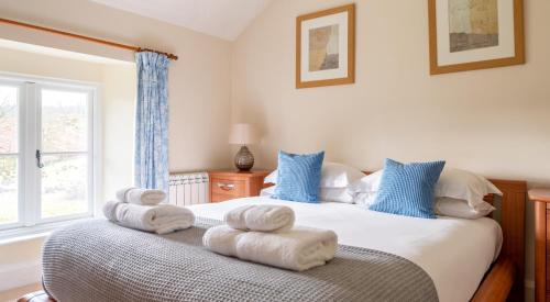 a bedroom with a bed with towels on it at Jubilee Cottage in Rusland