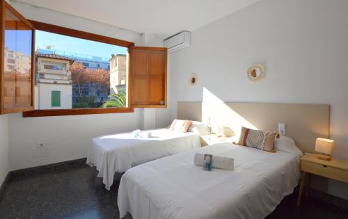 dwa łóżka w pokoju z oknem w obiekcie Villa Palma 2 w Palma de Mallorca