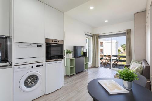 a kitchen and living room with a washer and dryer at Centralgarve - Elegant and Cosy Studio in the Heart of Vilamoura - Aldeia do Mar T0 in Vilamoura