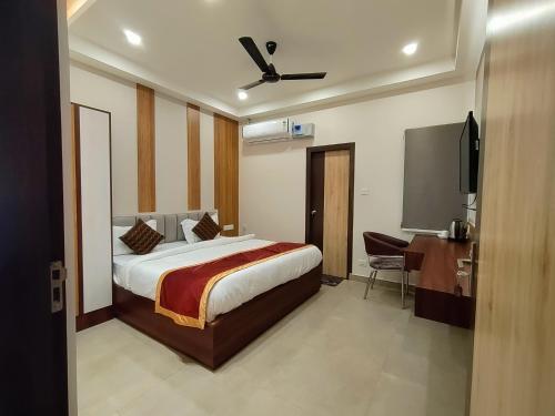 a bedroom with a bed and a desk and a tv at Royal Rooms and Banquet in Lucknow