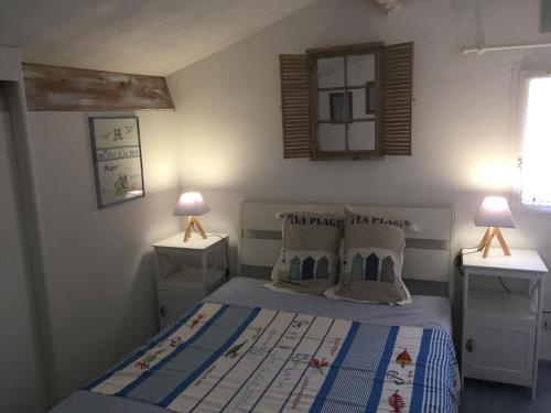 um quarto com uma cama e duas mesas de cabeceira em HOLIDAYLAND NARBONNE PLAGE Villas 6 ou 7 PERSONNES AVEC TERRASSE ET PLACE DE PARKING PRIVATIVE em Narbona